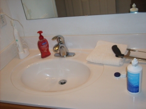 All the bathroom essentials.  Hand soap, tooth brush, contact solution, hack saw.